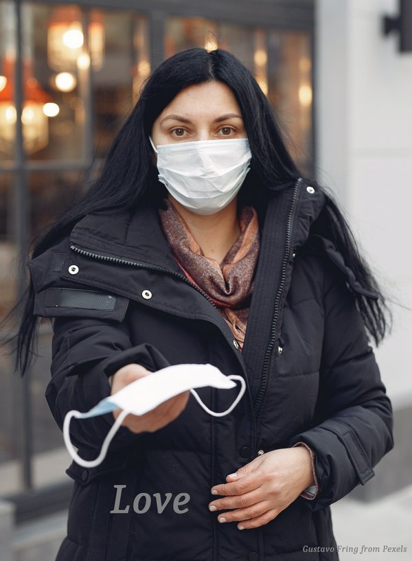 A woman wearning a mask offering a COVID mask