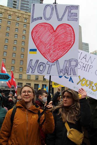 Demonstrators hold a sign saying &quot;Love not war&quot;