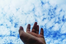 Hand reaching to heaven, photograph by Maila Hasso