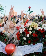 Protesters march holding bountiful flowers, making the peace sign; credit Artem Podrez from Pexels